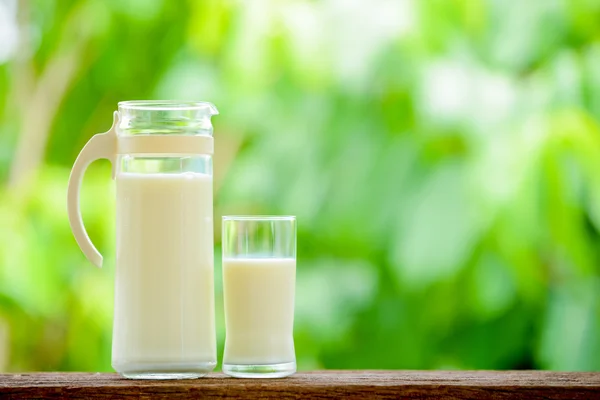 Milchkrug mit Glas — Stockfoto