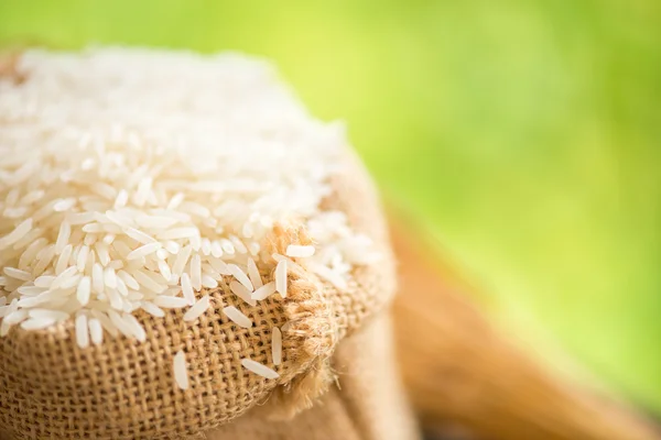 Arroz blanco en saco de arpillera con grano de arroz —  Fotos de Stock