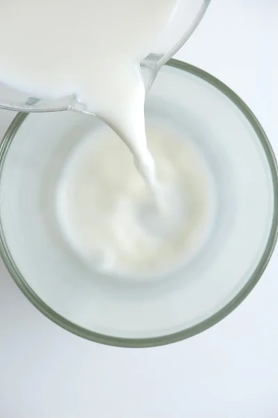 Milch in ein Glas gießen — Stockfoto