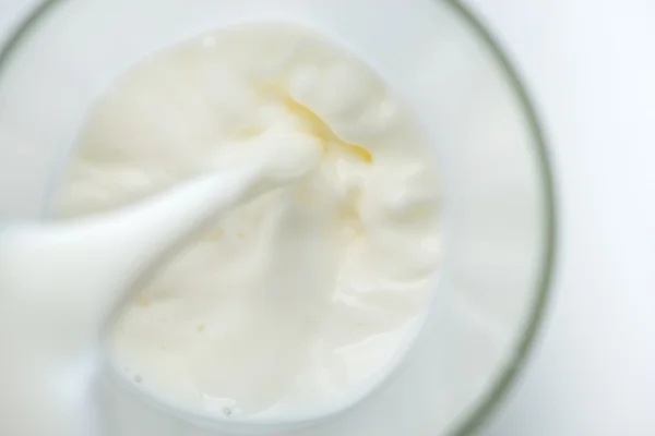 Pouring milk into a glass — Stock Photo, Image