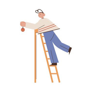 Çocuk merdivende duruyor ve Noel ağacını altın topla süslüyor.