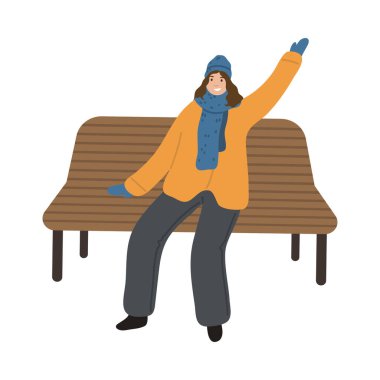 Sıcak giysili mutlu genç kadın bankta oturuyor ve arkadaşını selamlıyor.