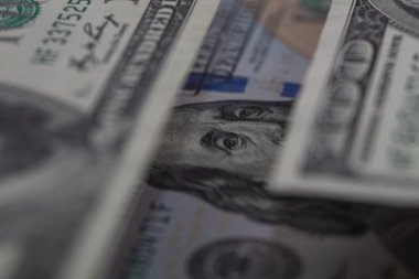 Benjamin Franklin 100 dolarlık banknotları dikizliyor.