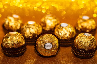 İtalya - 1 Ocak 2020: Ferrero Rocher altın parıltılı arka planda özel çikolata