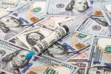 İçinde 100 dolarlık banknotlar bulunan şırınga.