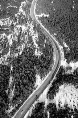 Kışın insansız hava aracından dağ yolunda hava manzarası. Siyah beyaz resim