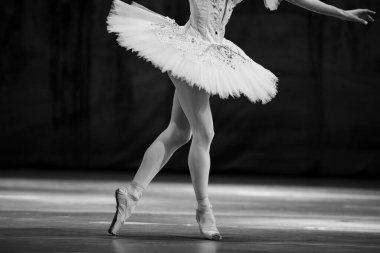 Sahnede yapayalnız dans eden balerinin yakın çekimi. Balerin bacakları yakın plan