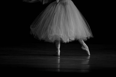 Sahnede yapayalnız dans eden balerinin yakın çekimi. Balerin bacakları yakın plan