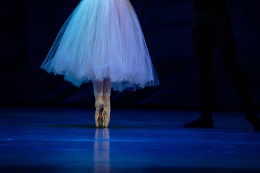 Sahnede yapayalnız dans eden balerinin yakın çekimi. Balerin bacakları yakın plan