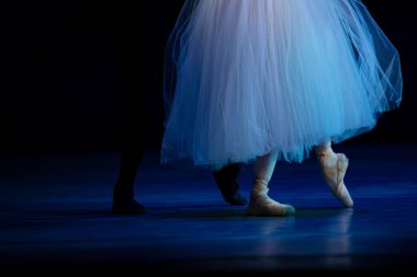 Sahnede yapayalnız dans eden balerinin yakın çekimi. Balerin bacakları yakın plan