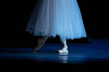 Sahnede yapayalnız dans eden balerinin yakın çekimi. Balerin bacakları yakın plan