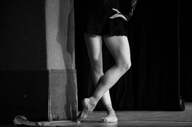 Sahnede yapayalnız dans eden balerinin yakın çekimi. Balerin bacakları yakın plan