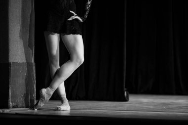 Sahnede yapayalnız dans eden balerinin yakın çekimi. Balerin bacakları yakın plan