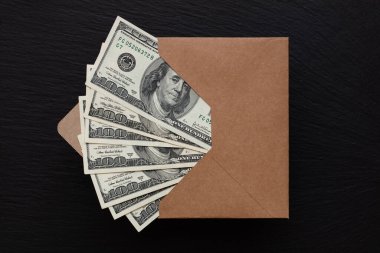 Siyah arka planda el yapımı zarfla 100 dolarlık banknot.