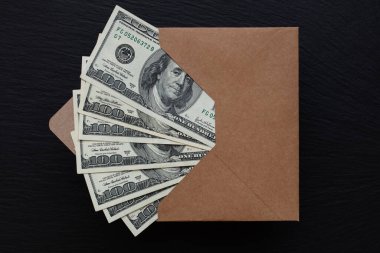 Siyah arka planda el yapımı zarfla 100 dolarlık banknot.