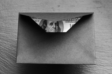 Siyah arka planda el yapımı zarfla 100 dolarlık banknot.