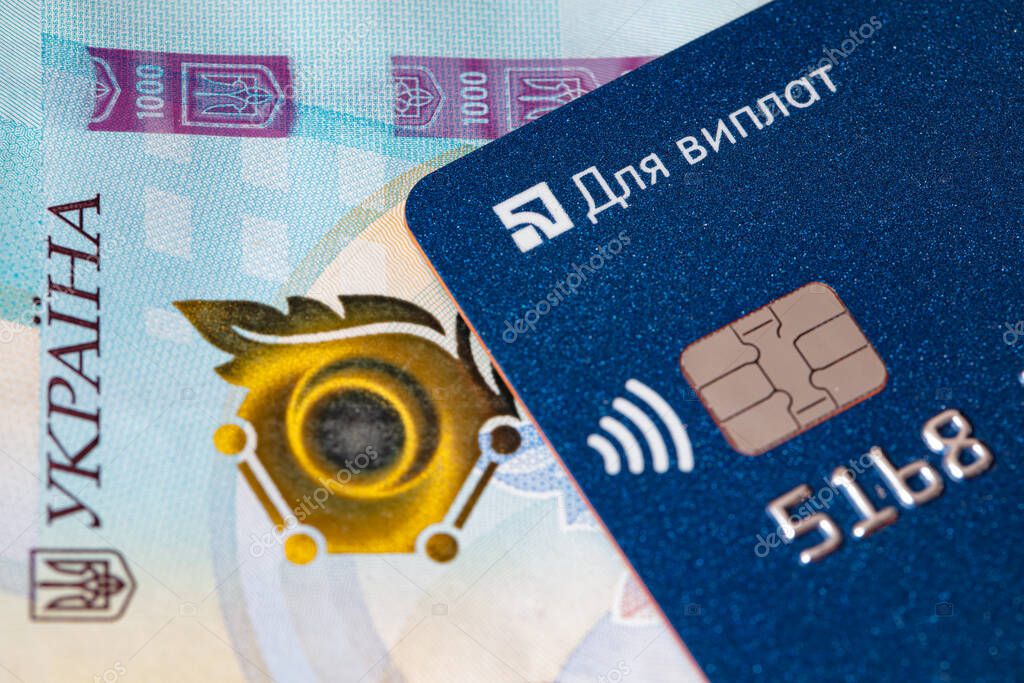 Kyiv, Ukraine -April 10, 2021: Debit card on 1000 Ukrainian hryvnia banknote