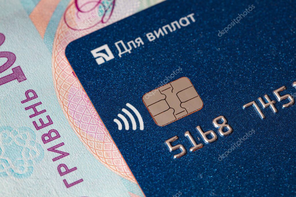 Kyiv, Ukraine -April 10, 2021: Debit card on 1000 Ukrainian hryvnia banknote