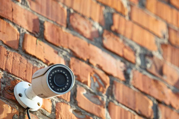 security camera on red brick wall background
