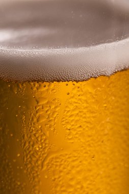Extreme Close-up of Cold Golden Beer Foam and Condensation