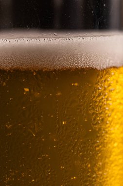 Extreme Close-up of Cold Golden Beer Foam and Condensation