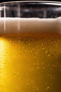 Extreme Close-up of Cold Golden Beer Foam and Condensation