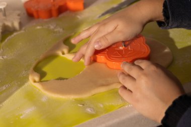 Çocuk Elleri Turuncu Kesiciyle Balkabağı Şeklinde Kurabiye Kesiyor