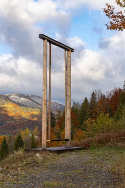 Panoramik sonbahar dağ manzaralı dev ahşap salıncak.