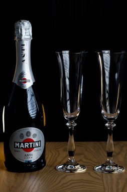 Lviv, Ukrayna - 4 Kasım 2025: Martini Asti köpüklü şarap şişesi ve iki kristal bardak