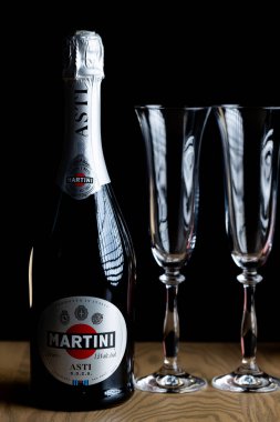 Lviv, Ukrayna - 4 Kasım 2025: Martini Asti köpüklü şarap şişesi ve iki kristal bardak