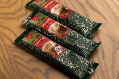 Lviv, Ukrayna - 11 Kasım 2025: Üç Jacobs Cappuccino Klasik Anlık Kahve Sachets on Wood
