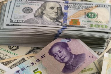 Yığınla Amerikan 100 Dolarlık banknot Çin 5 Yuan 'lık banknotla kaplı.
