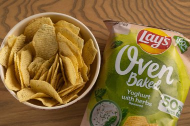 Lviv, Ukrayna - 16 Kasım 2025: Lay 's Oven Fırınlanmış Yoğurt Odun Masasında Paketleme ile bir kasede cips