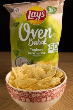 Lviv, Ukrayna - 16 Kasım 2025: Lay 's Oven Fırınlanmış Yoğurt Odun Masasında Paketleme ile bir kasede cips