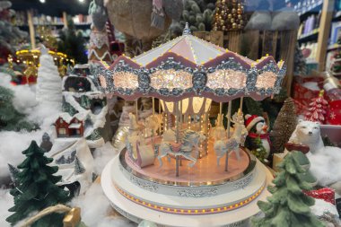 Tasarım amaçlı olarak kış mağazasının vitrininde aydınlatılmış Noel atlıkarıncası