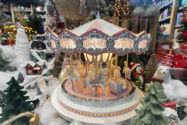 Tasarım amaçlı olarak kış mağazasının vitrininde aydınlatılmış Noel atlıkarıncası