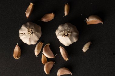 Taze sarımsak soğanları ve koyu desenli arkaplanda karanfiller