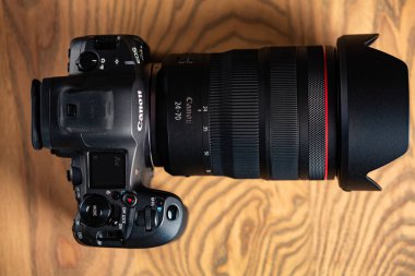 Lviv, Ukrayna - 20 Şubat 2026: Profesyonel aynasız kamera Canon EOS R5 Mark II ve RF 24-70 mm f / 2.8L lensler tahta masa üzerinde