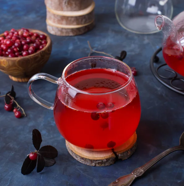 一杯热红莓茶和一个茶壶在黑暗寒冷的背景 用浆果加热和治疗茶 新年的饮料 一个温馨的夜晚 — 图库照片