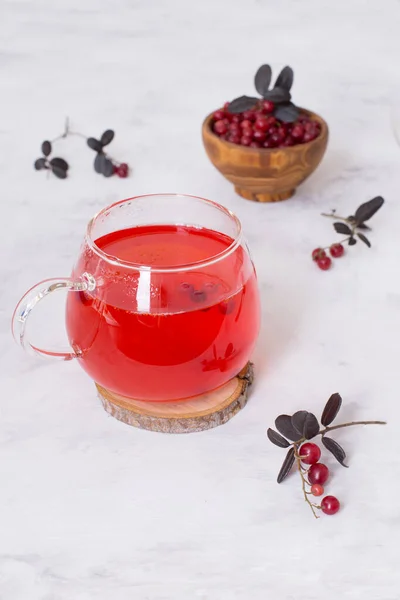 在淡淡的背景下 在玻璃杯中享用热红莓茶 用浆果加热和治疗茶 新年的饮料 一个温馨的夜晚 — 图库照片