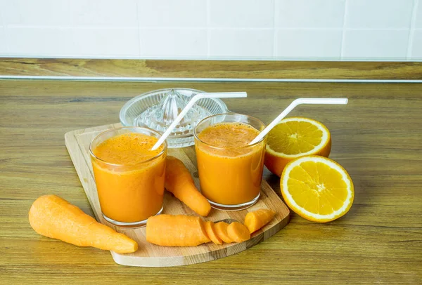 Fresh carrot juice in glass cups. Cocktail of carrot and orange juice with flax seeds.