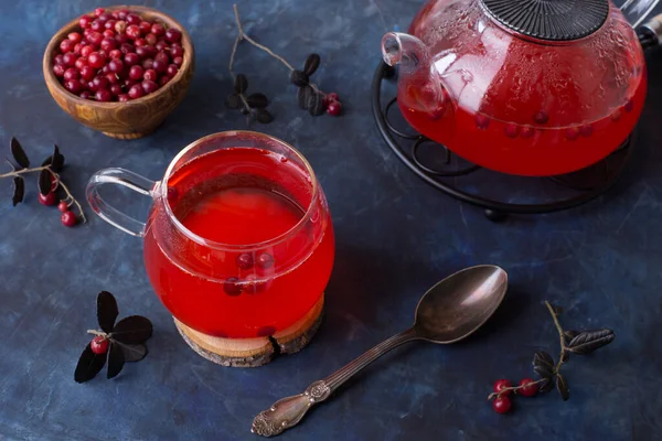 一杯热红莓茶和一个茶壶在黑暗寒冷的背景 用浆果加热和治疗茶 新年的饮料 一个温馨的夜晚 — 图库照片