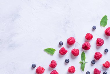 Hafif arkaplanda ahududu ve yaban mersini süsü. Böğürtlenli yaz. Üst görünüm.