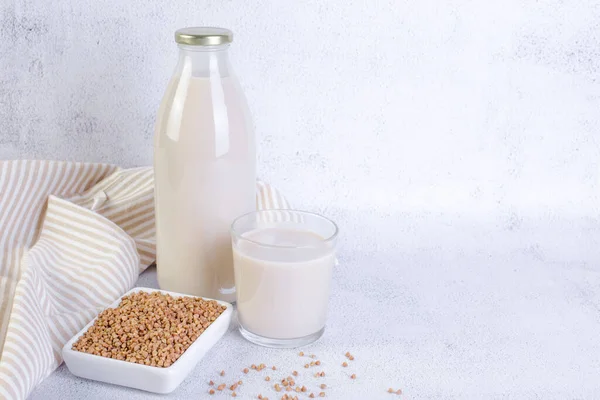 Buckwheat milk in glass bottle and glass.The concept of healthy vegetarian food and drinks. Gluten-free products.