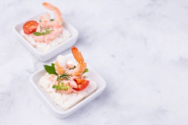 Domatesli ve roka arkaplanlı lezzetli karides kanepeleri. Deniz mahsulleriyle birlikte ziyafet aperatifi. Boşluğu kopyala.
