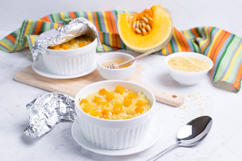 Millet porridge with pumpkin slices in light forms for baking on a light background. Vegetarian diet. Traditional autumn cuisine. horizontal.