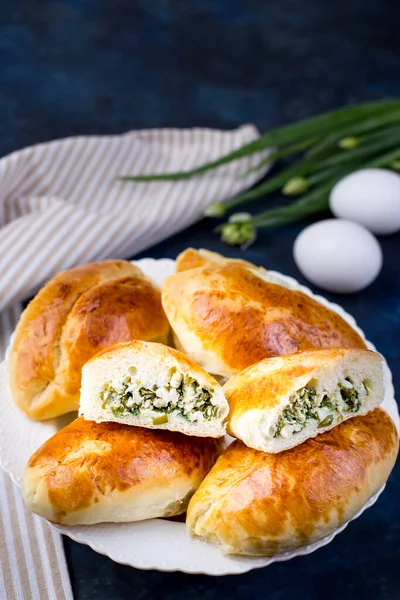 Leckere kleine Kuchen mit grünen Zwiebeln und Ei. Traditionelle russische Küche. Hausgemachte Kuchen. Stockfoto