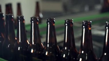 Modern bir bira fabrikasının dolum hattında kahverengi şişeler. Yakın plan.