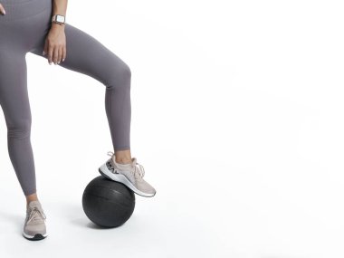 Güzel atletik kadın bacakları tıbbi bir topun üzerinde duruyor. Kopyalama Aralığı.