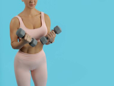 Güzel, sportif bir kadın gri halterlerle egzersiz yapıyor. Kopyalama Aralığı.